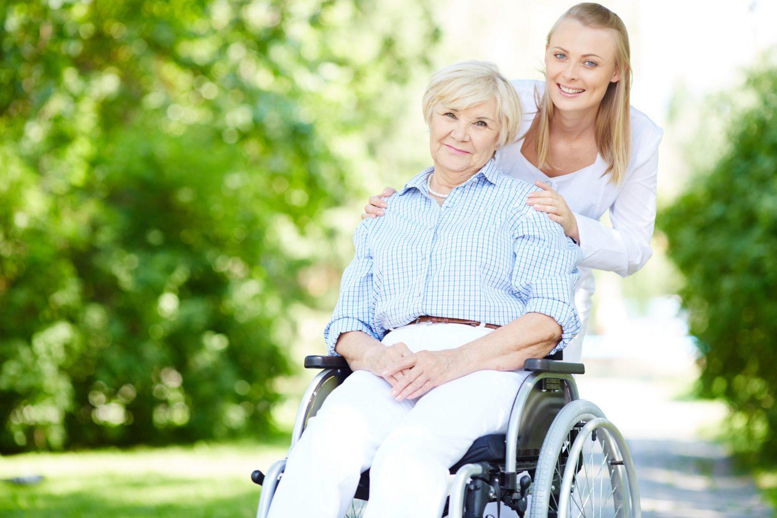 caregiver-pushing-senior-woman-in-wheelchair-kw4n4gap